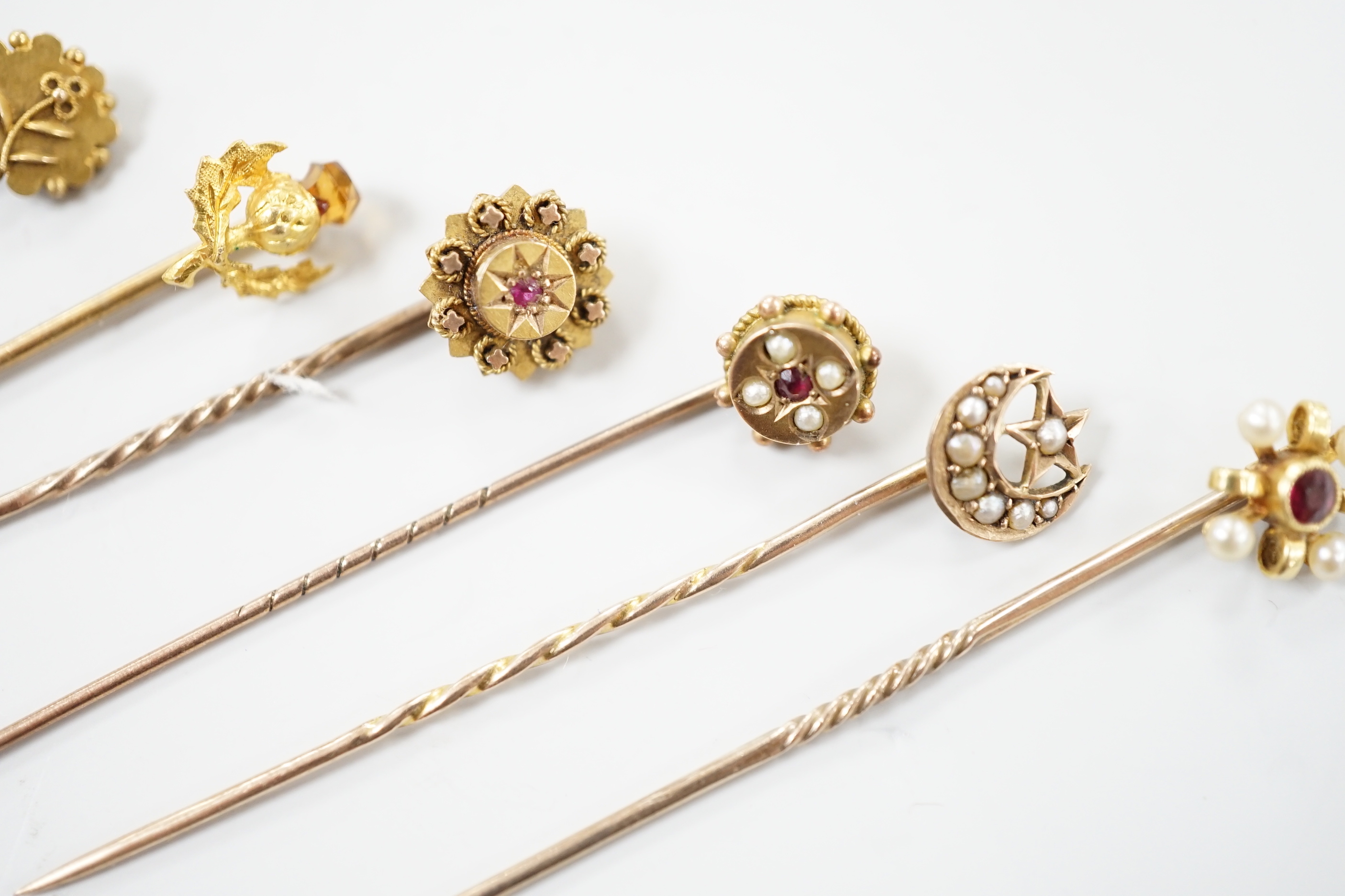 Three early 20th century 15ct stick pins including gem, three similar 9ct stick pins and one other yellow metal and white opal set stick pin, largest approx. 57mm.